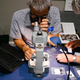Jose Leal looks at tiny shells under a microscope while Phylis Sharp jots down what each one he identifies is.